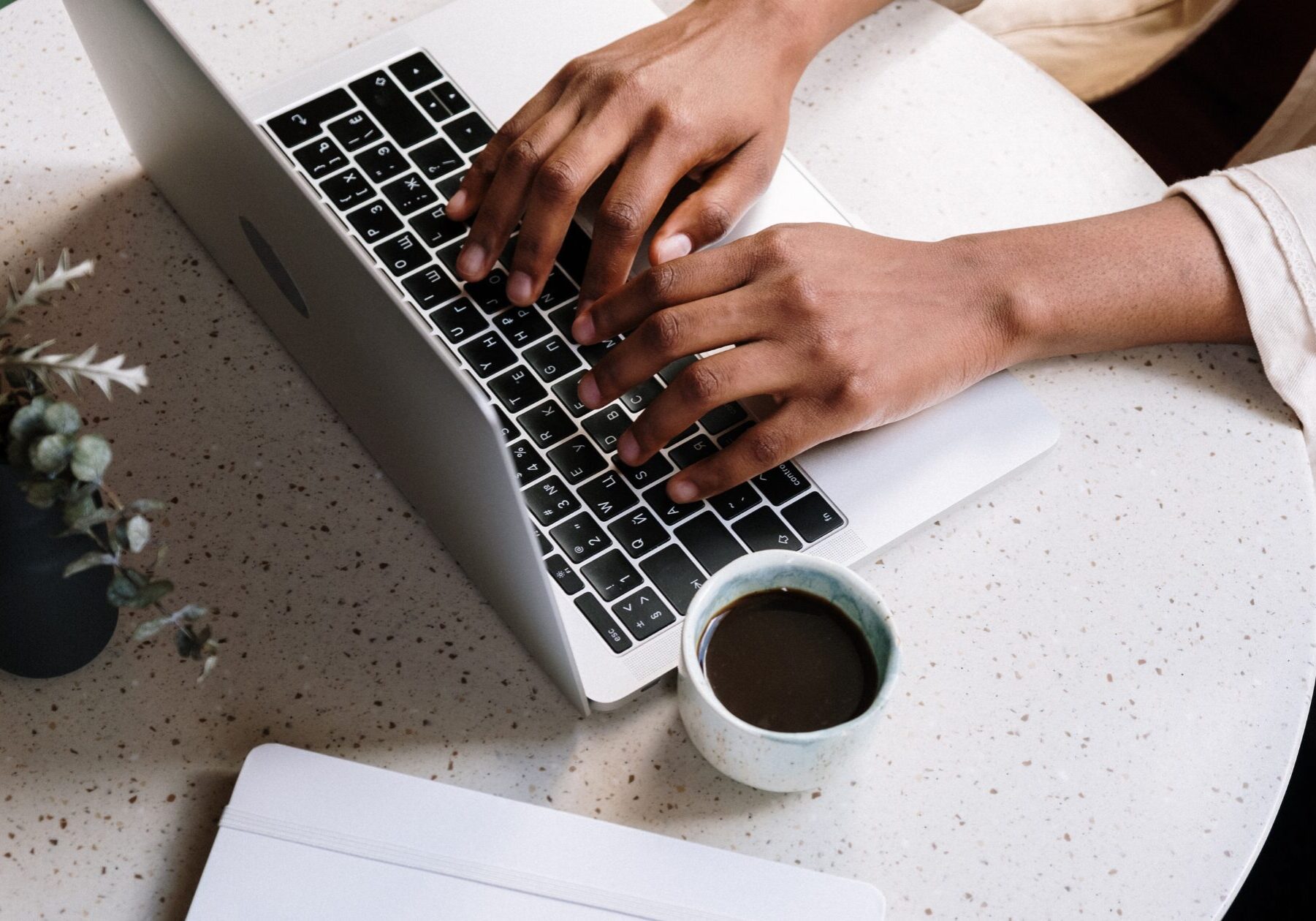 Hands are typing on a laptop