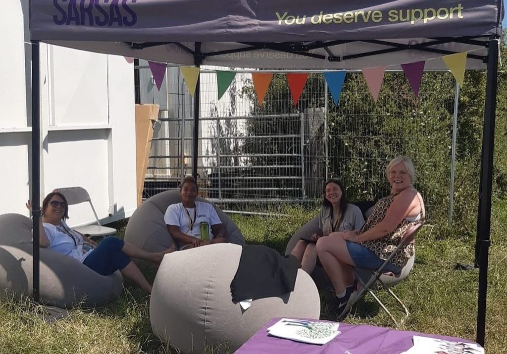 4 women sitting under a gazebo