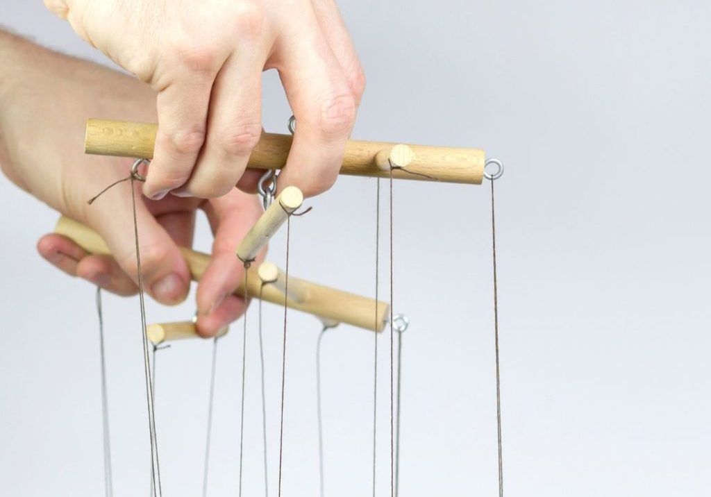 hands holding puppet strings