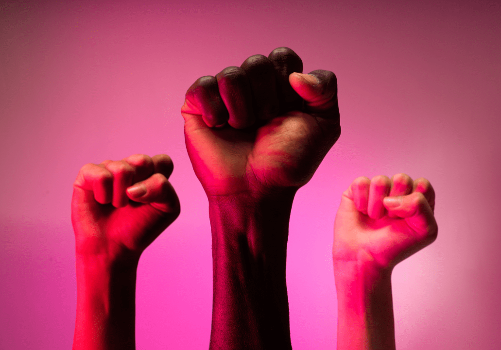 Untitled design (23) three arms up with hands held in fists