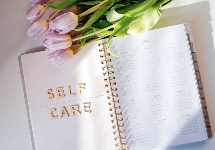 a opened journal with the words self-care on