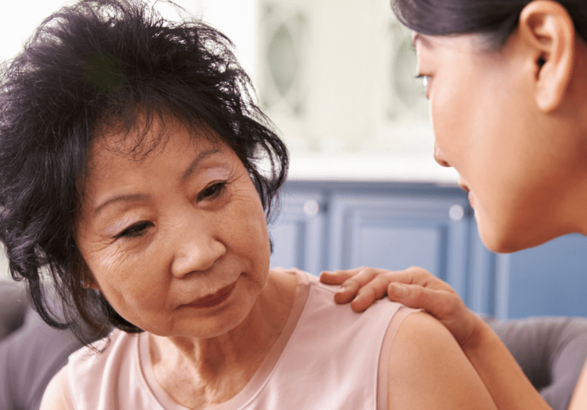 Untitled design (9) On older woman of East Asian ethnicity is being comforted by a younger woman of East Asian ethnicity