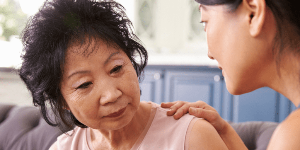 On older woman of East Asian ethnicity is being comforted by a younger woman of East Asian ethnicity