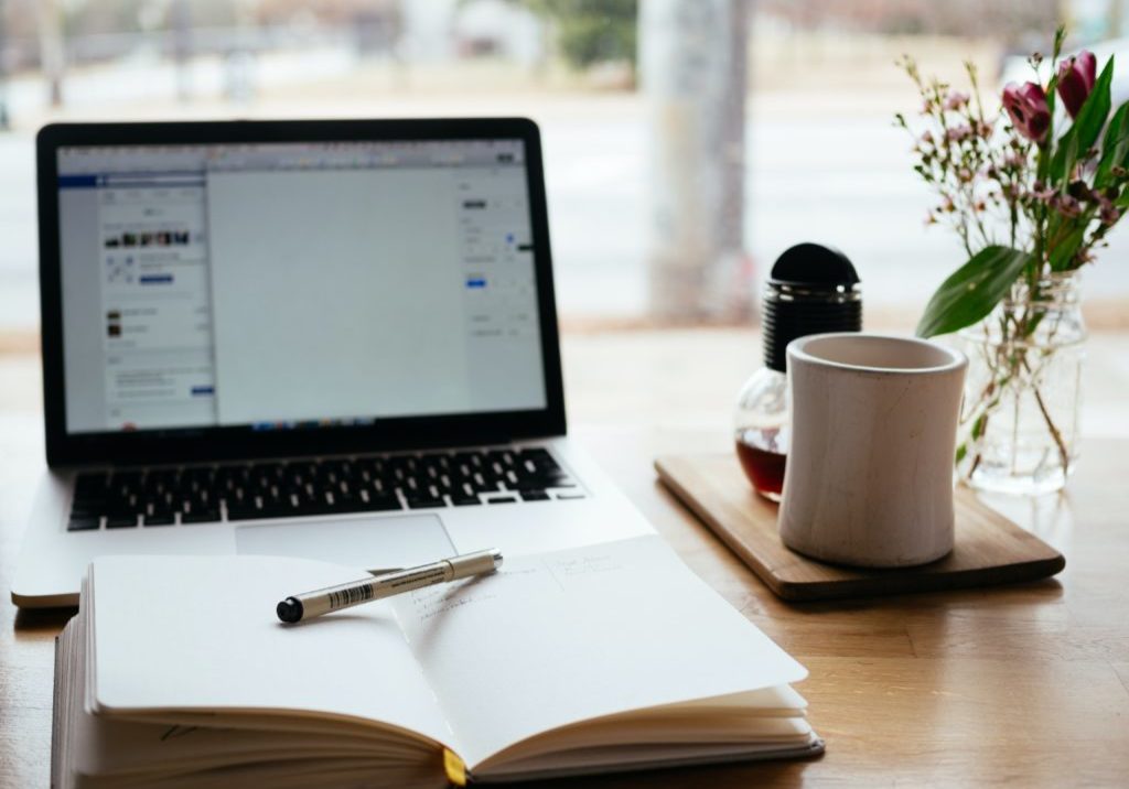 A desk set up for studying with a laptop and note pad