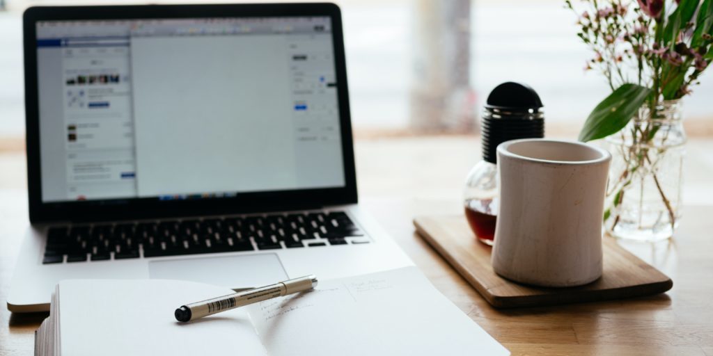 A desk set up for studying with a laptop and note pad